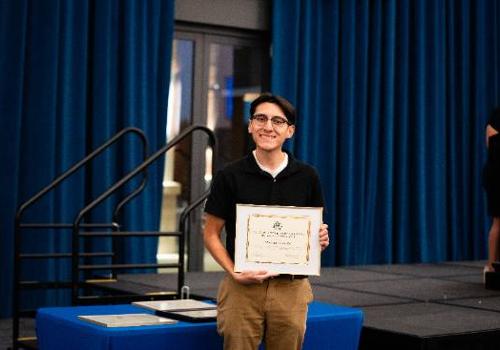 Rolando Castillo Holds a Plaque Received During His Trailblazer Elite Pinning Ceremony