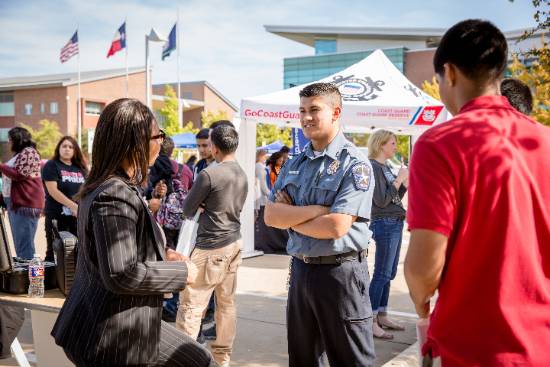 Guests Visit with a Police Officer at a Campus Public Safety Event