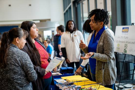 A Young Woman and Her Mother Talk with a Professor at the 2023 True Blue Open House