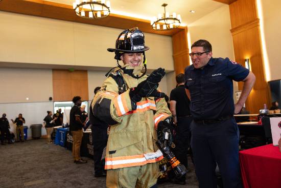 A High School Student Wears Firefighting Gear with Help from the Arlington Fire Dept.