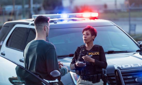 A Police Officer Interviews a Witness at a Crime Scene