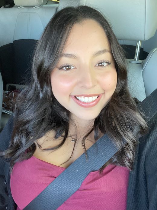 Kristy in a pink top smiling in her car